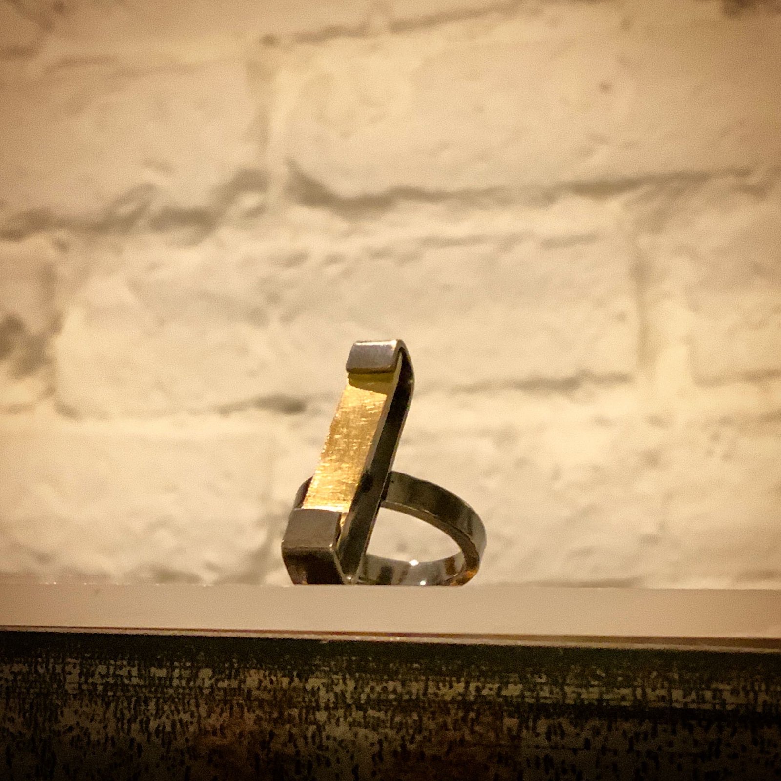 Anillo minimalista de Ganboa Jewellery apoyado contra una pared de piedra del Casco Viejo de Bilbao