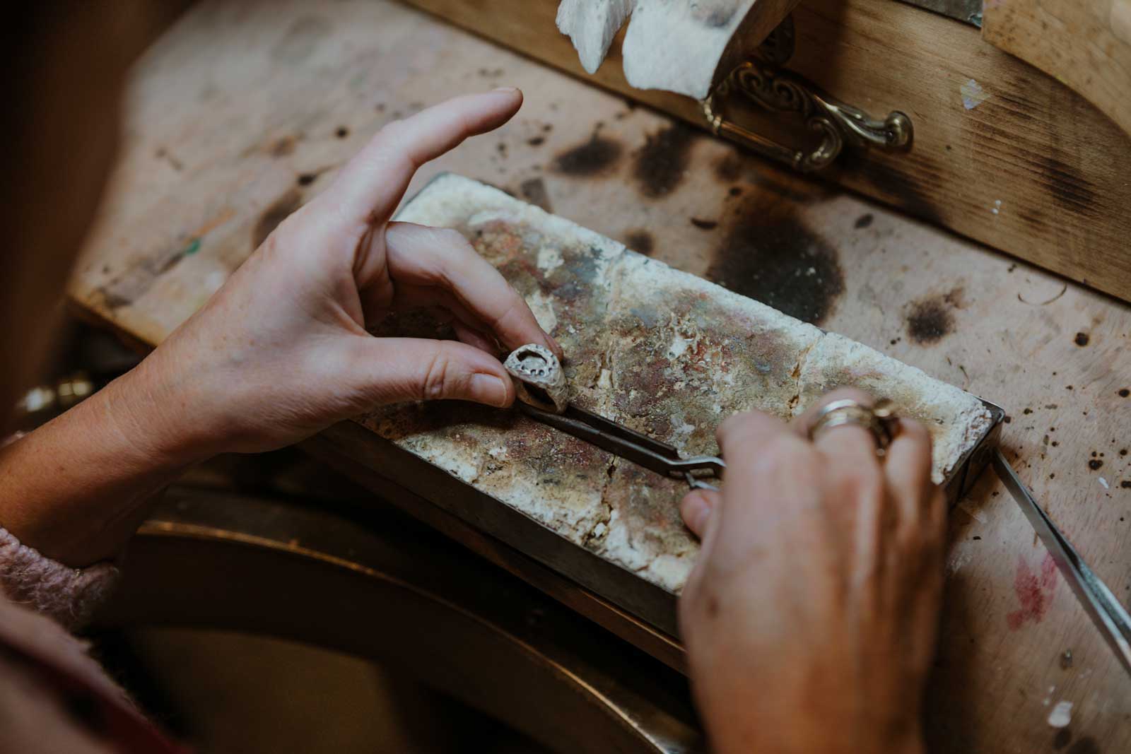 Manos de Maitena Ganboa trabajando una pieza de plata con herramientas de joyería